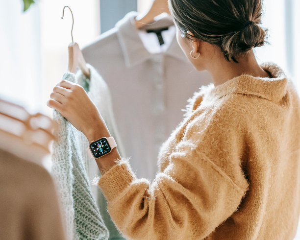 A woman browses through hung clothing